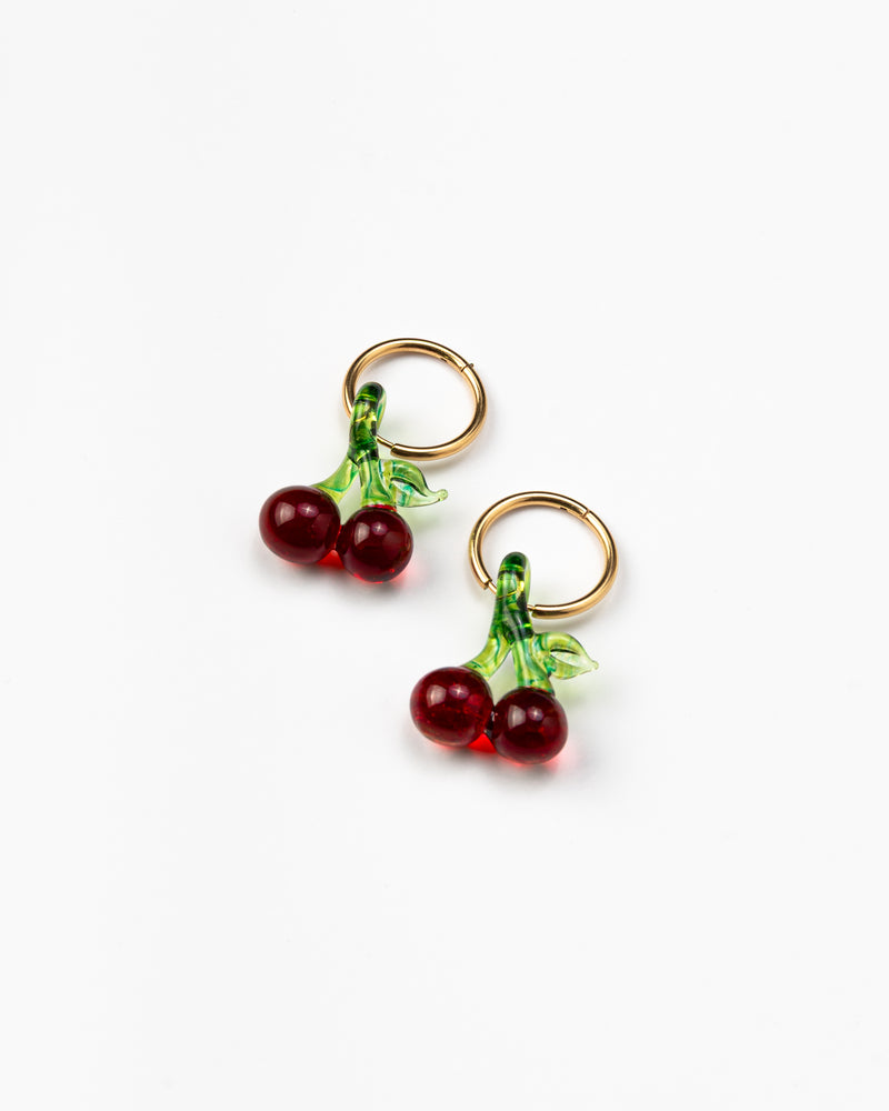 Earrings in the shape of two pairs of cherries, on a gold hoop, made from recycled glass.