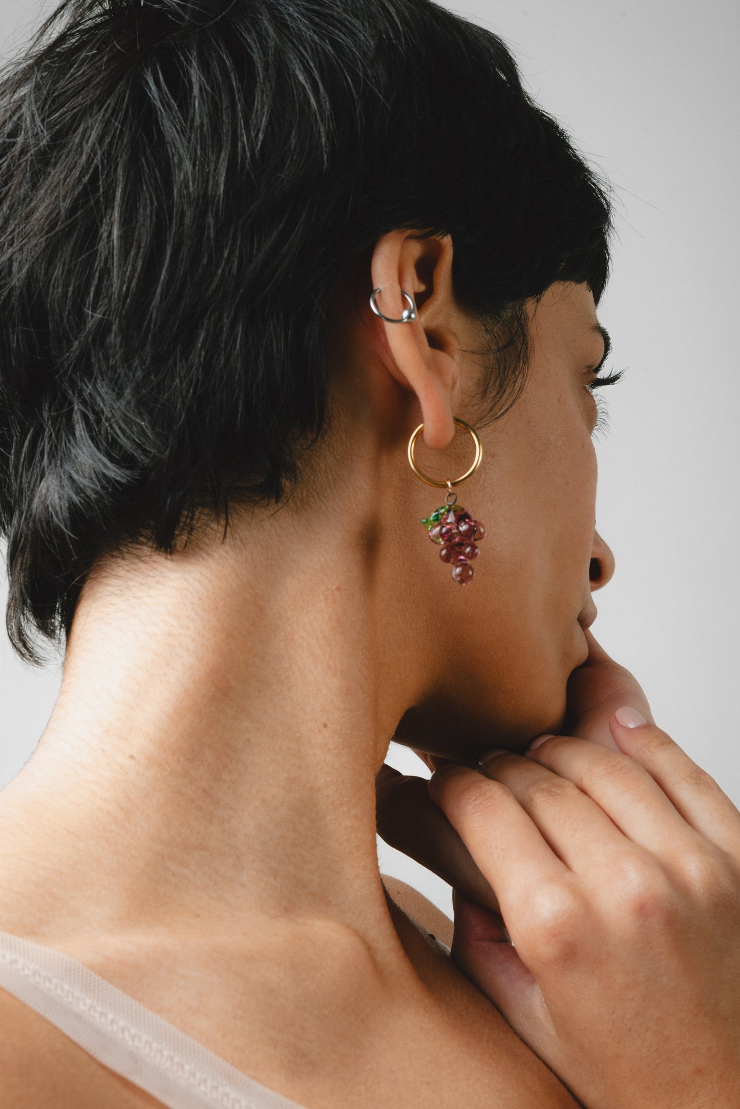 Gold hoop earrings with purple grape-shaped pendants with green leaves, handcrafted from recycled glass