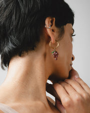 Gold hoop earrings with purple grape-shaped pendants with green leaves, handcrafted from recycled glass
