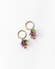 Gold hoop earrings with purple grape-shaped pendants with green leaves, handcrafted from recycled glass.