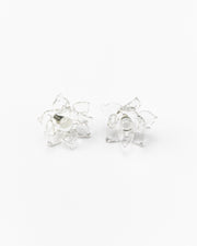 A pair of clear Pavonia stud earrings in a shape of a flower with spiky petals, made from recycled glass
