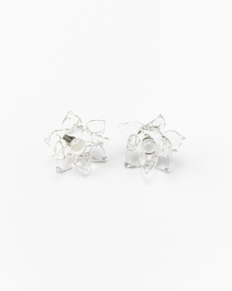 A pair of clear Pavonia stud earrings in a shape of a flower with spiky petals, made from recycled glass