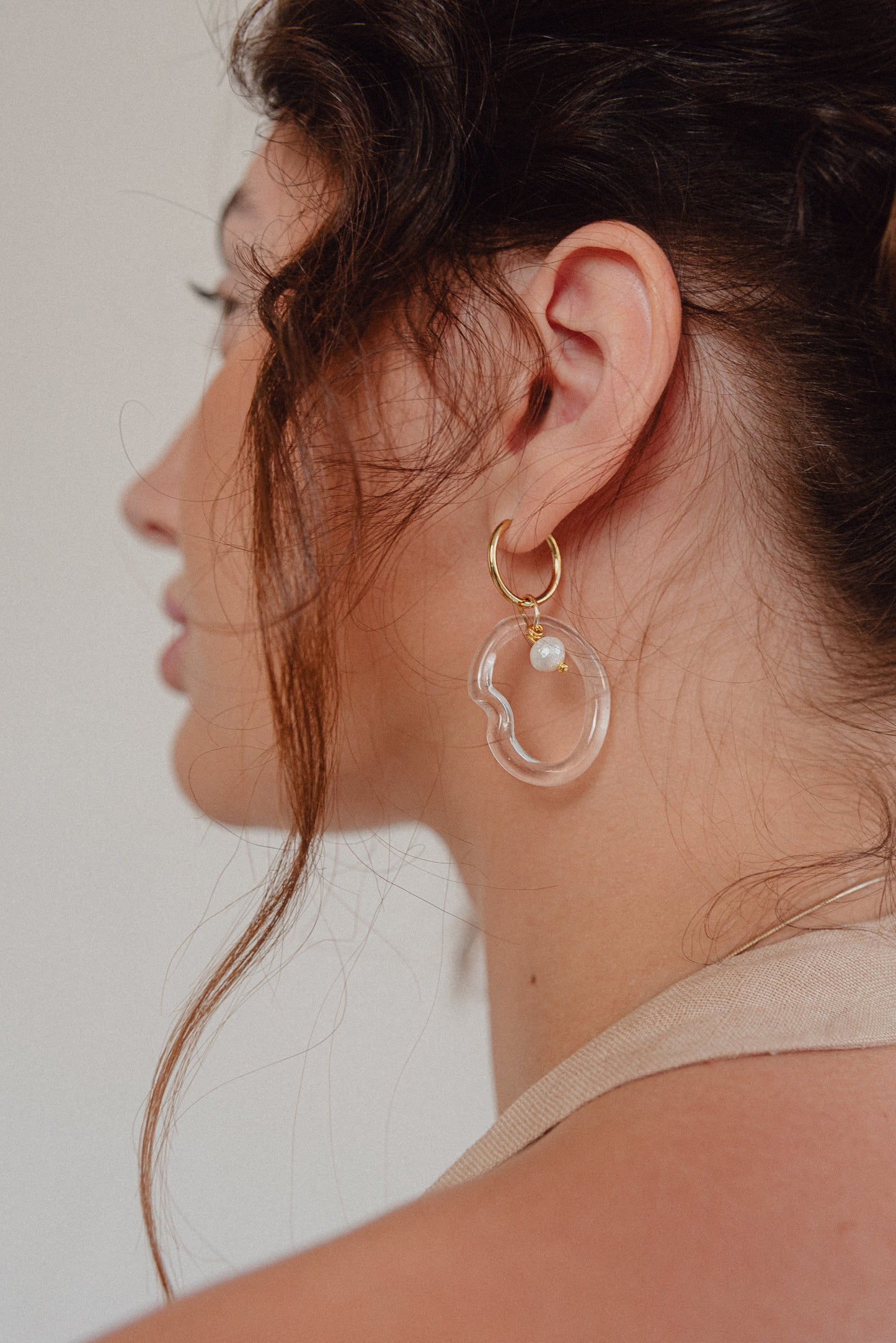 Clear Ameba dangle-hoop earrings on a base of gold stainless steel, with a river pearmade from recycled glass,