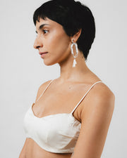 Clear dangle earrings with three pearls on one side, on a base of silver stainless steel, made from recycled glass