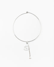 A silver necklace featuring a clear pendant in the shape of a shell, made from recycled glass, and a drop chain with a white pearl at the end