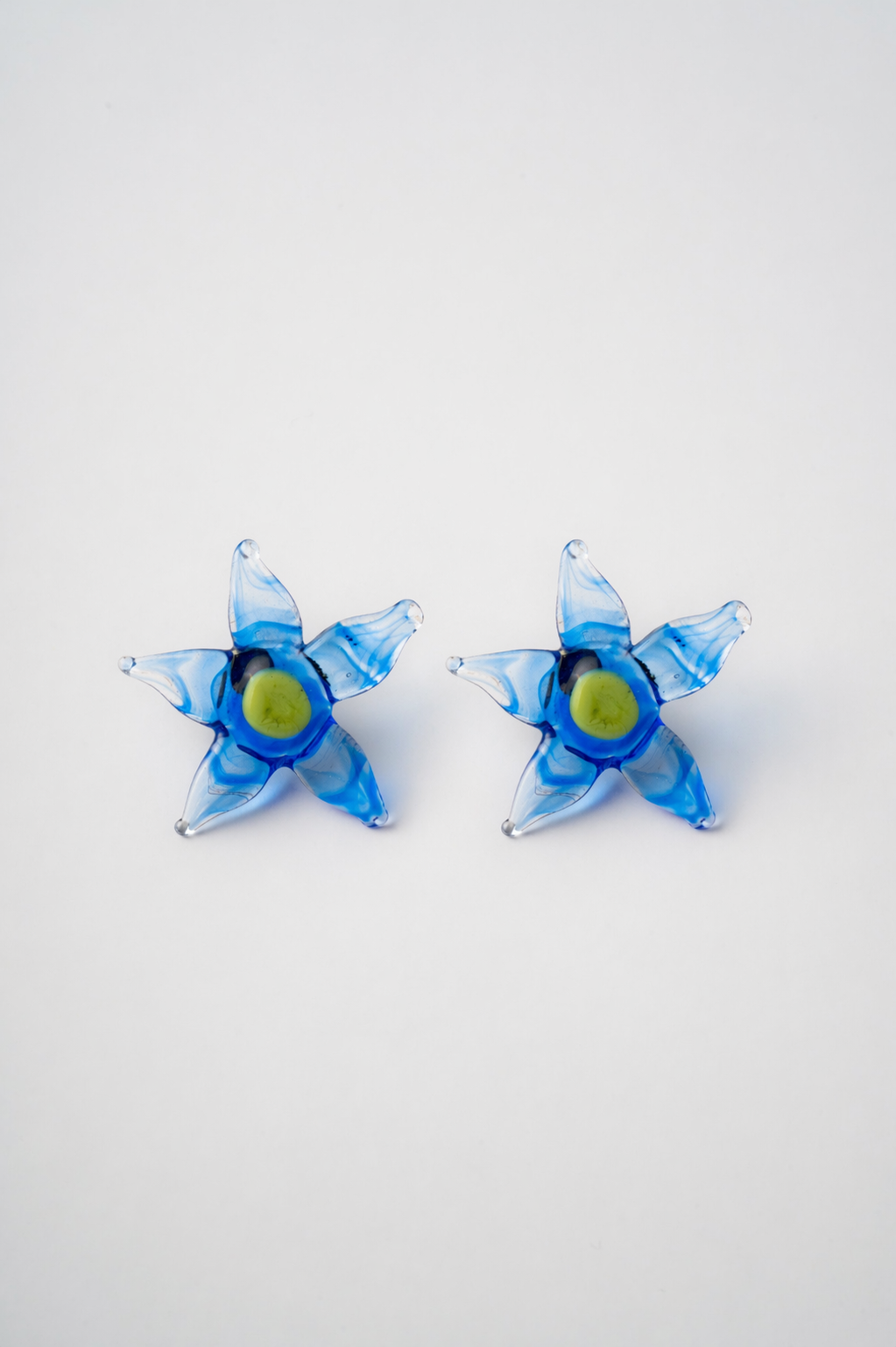 Pair of blue flower-shaped earrings on a white background