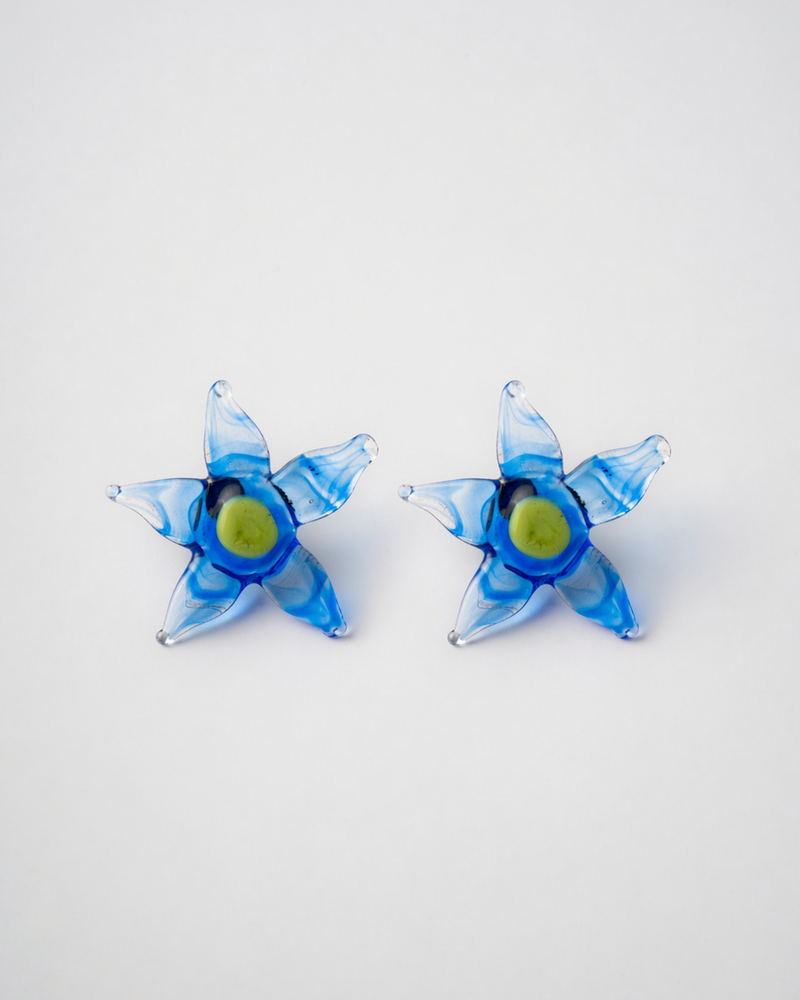 Pair of blue flower-shaped earrings on a white background
