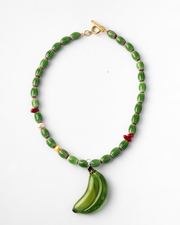 Necklace with green beads and a banana-shaped pendant on a white background