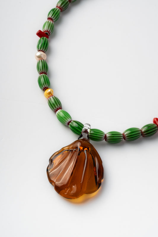 Handmade necklace with green beads and a large amber pendant 