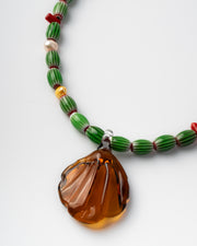 Handmade necklace with green beads and a large amber pendant 