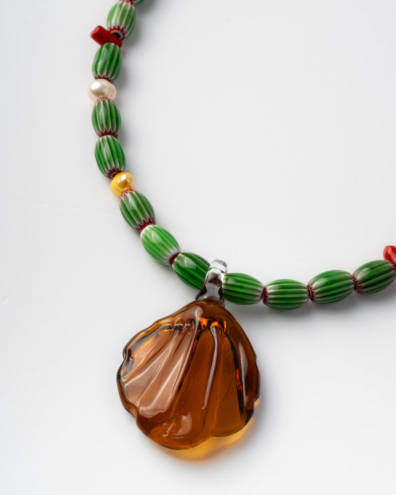 Handmade necklace with green beads and a large amber pendant 