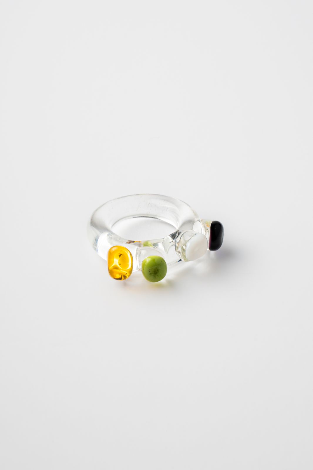 Glass Ring with multicolored stones on a light gray background