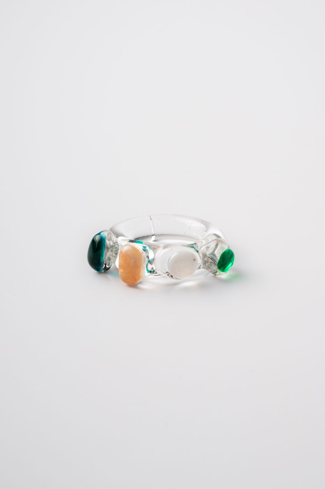 Glass Ring with multicolored stones on a light gray background