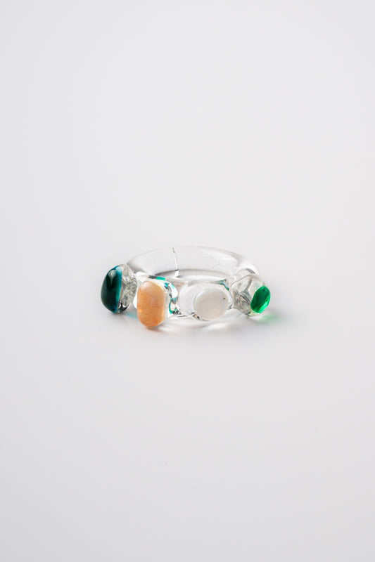 Glass Ring with multicolored stones on a light gray background