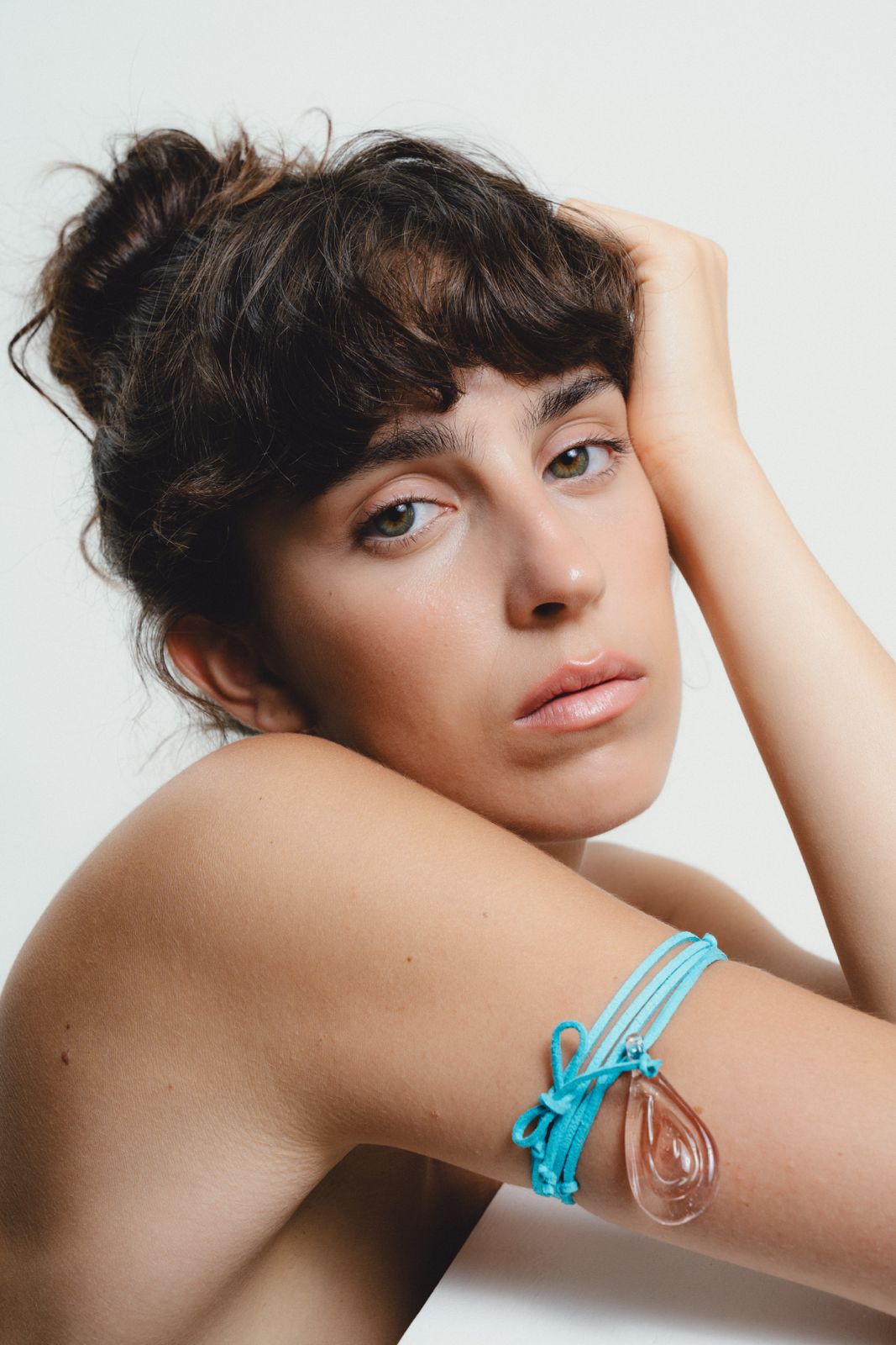 Turquoise cord necklace with a teardrop pendant on a white background