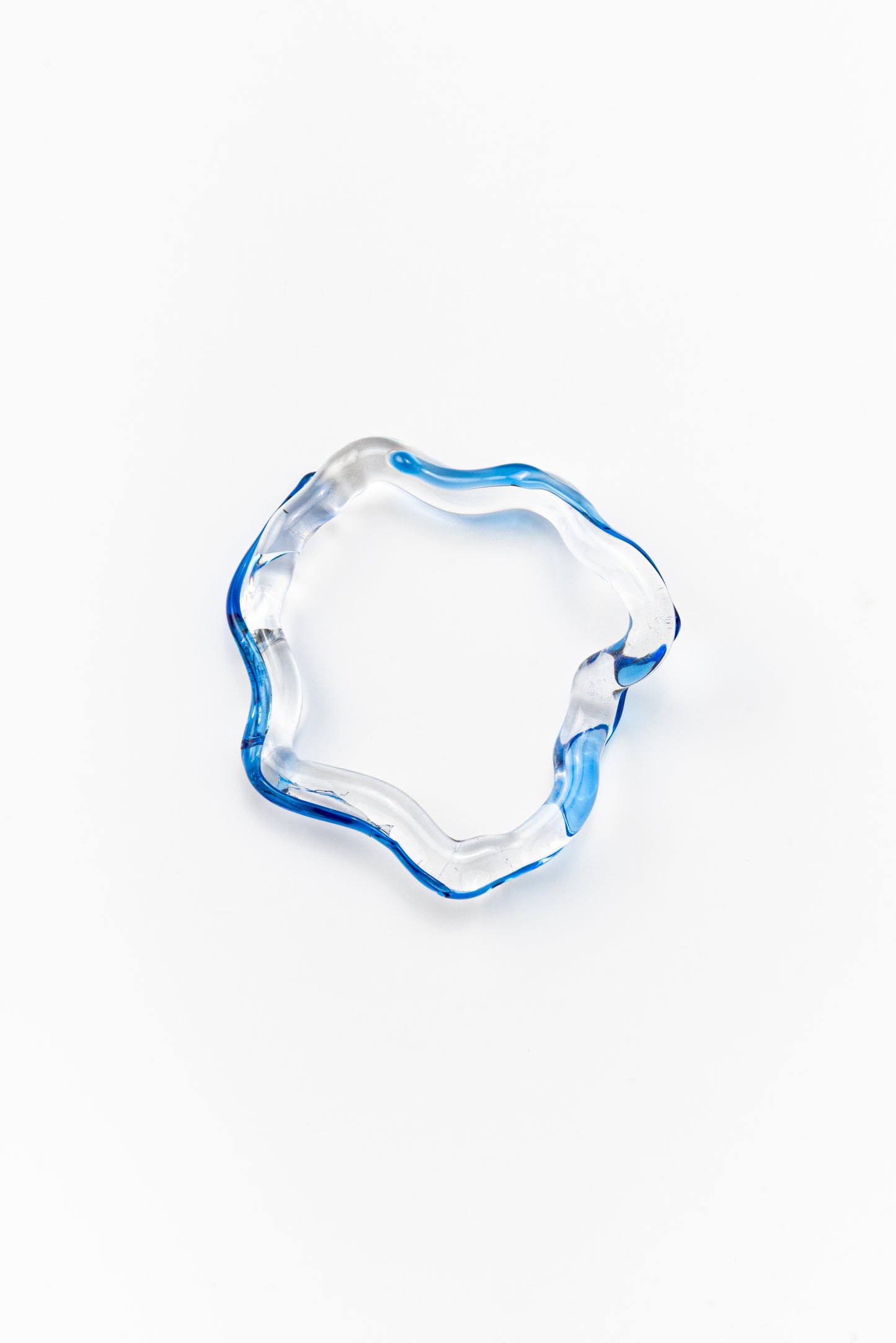 Wavy-shaped bracelet made of clear recycled glass with blue accents