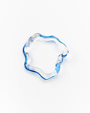Wavy-shaped bracelet made of clear recycled glass with blue accents