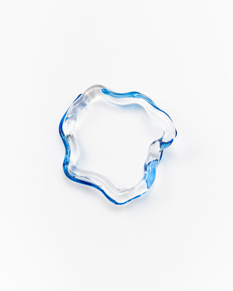 Wavy-shaped bracelet made of clear recycled glass with blue accents