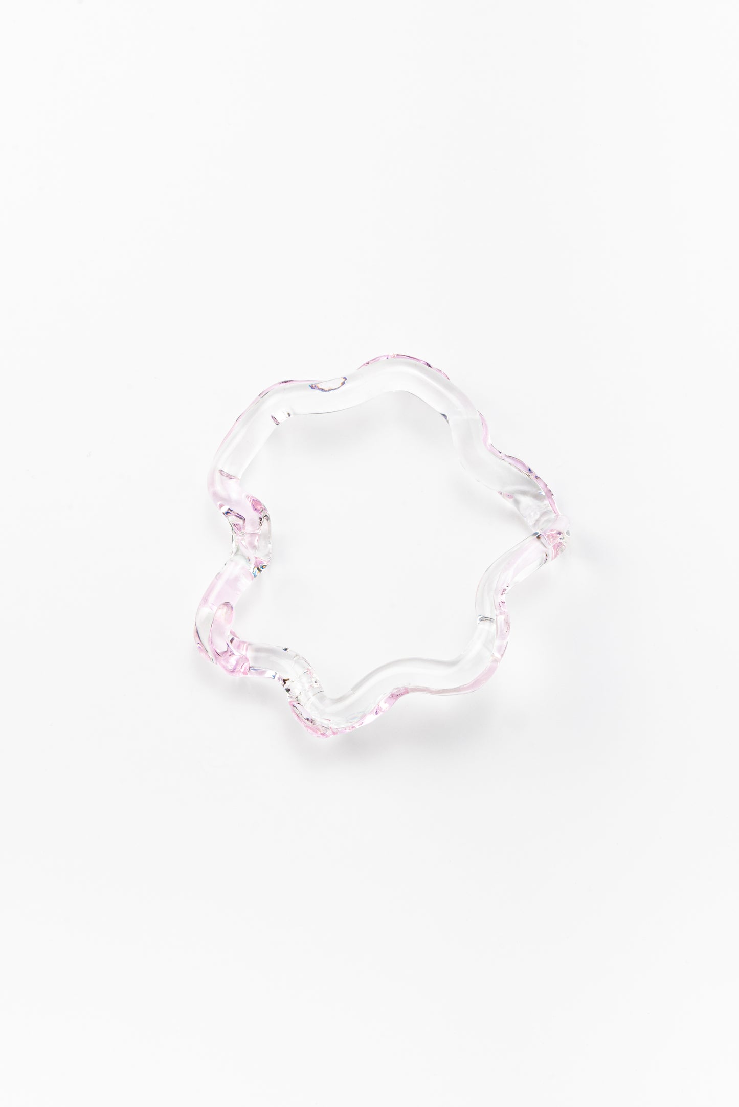 Wavy-shaped bracelet made of clear recycled glass with subtle pink accents