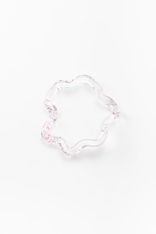 Wavy-shaped bracelet made of clear recycled glass with subtle pink accents