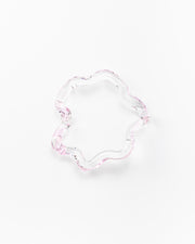 Wavy-shaped bracelet made of clear recycled glass with subtle pink accents