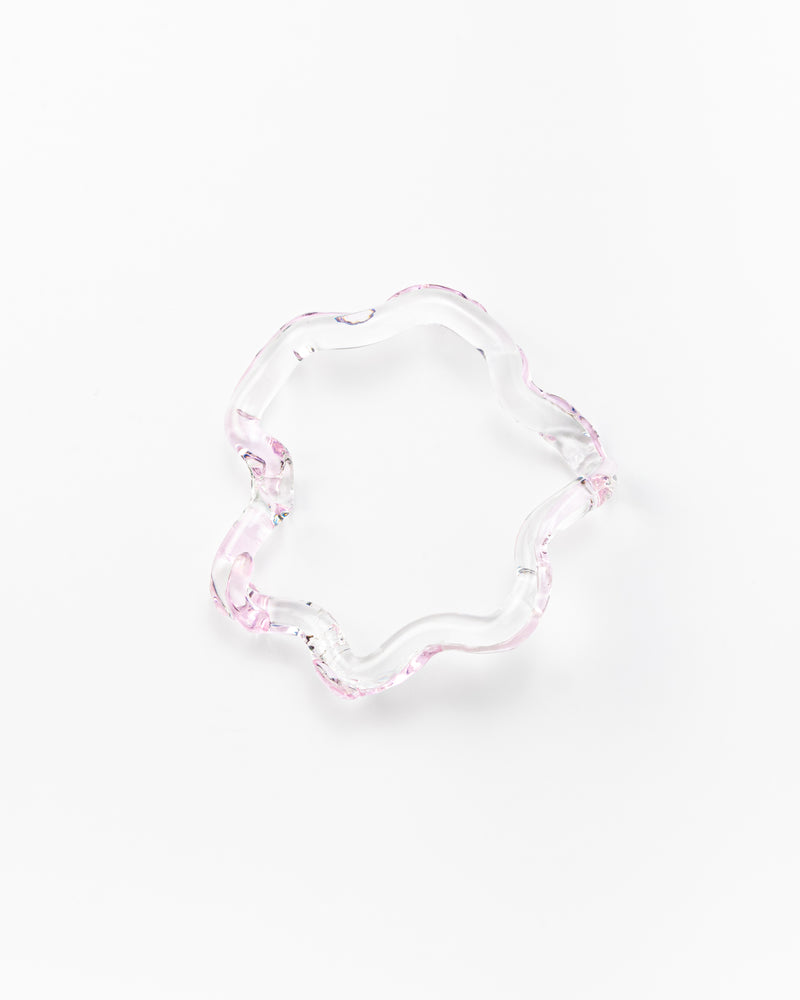 Wavy-shaped bracelet made of clear recycled glass with subtle pink accents
