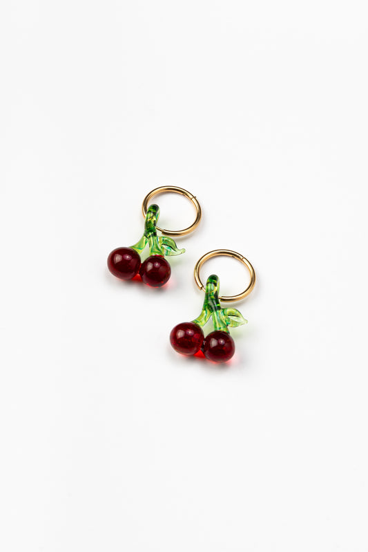 Earrings in the shape of two pairs of cherries, on a gold hoop, made from recycled glass.