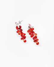 Dangle earrings with red sphere clusters and clear studs, made from recycled glass.