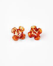 Pair of flower-shaped earrings made from translucent recycled glass in vibrant amber and red tones