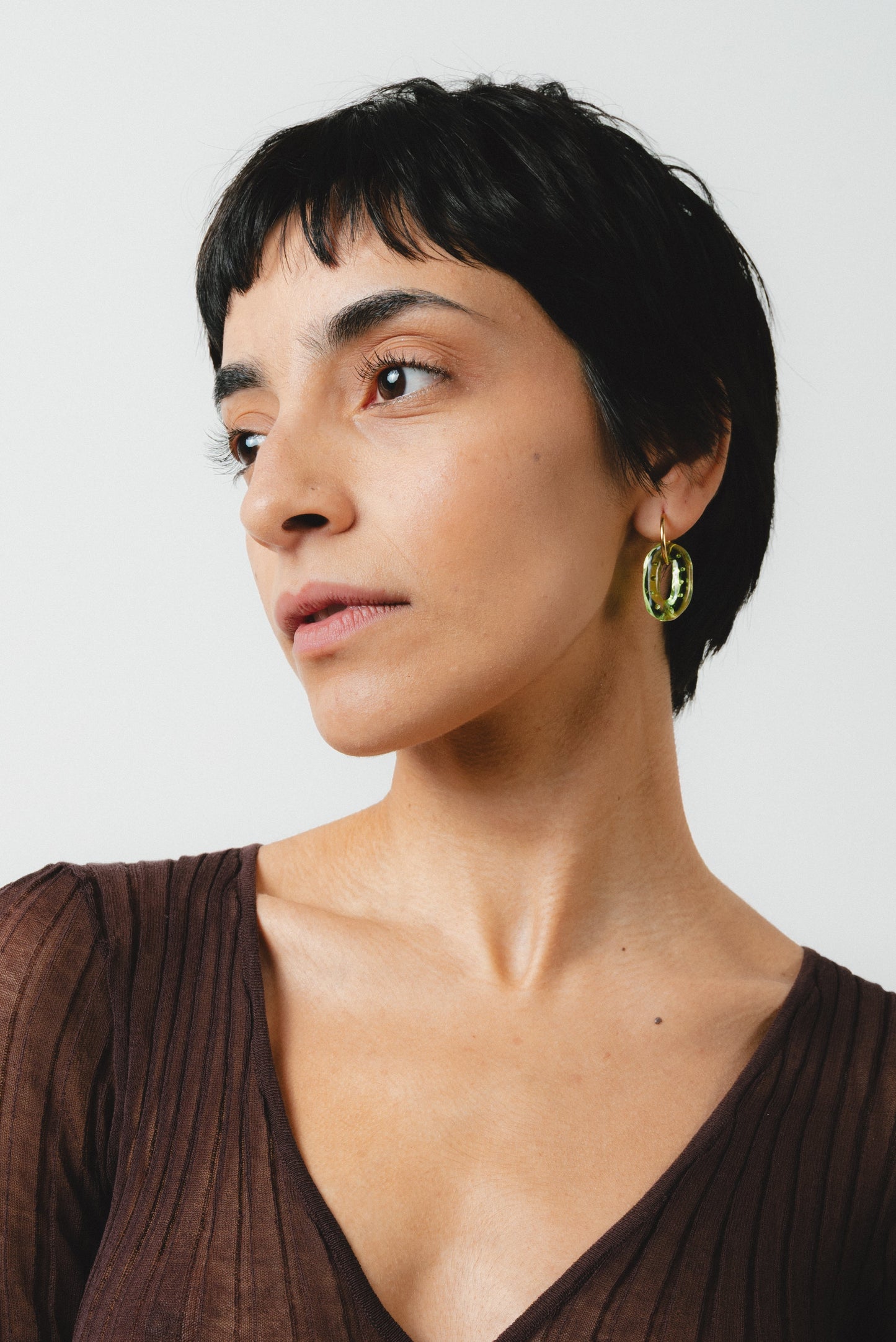 Gold Shinny hoop earrings with translucent green recycled glass loops containing small air bubbles.
