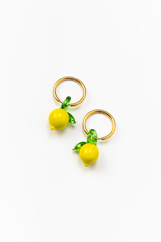Gold hoop earrings featuring small yellow lemon-shaped pendants with green leaves, made from recycled glass