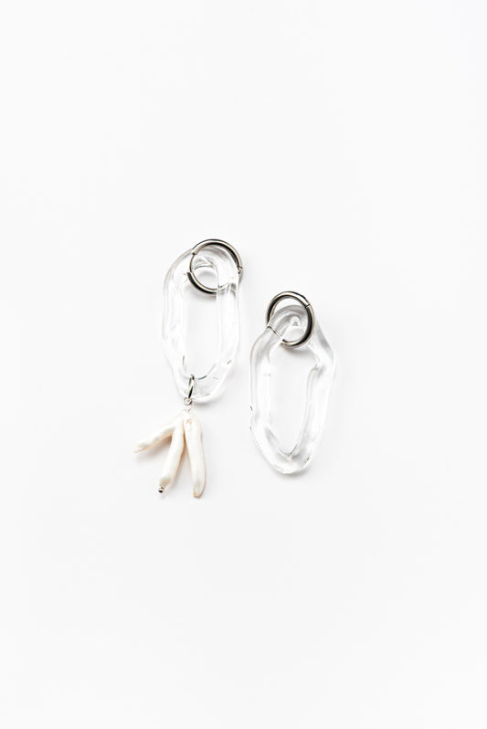 Clear dangle earrings with three pearls on one side, on a base of silver stainless steel, made from recycled glass