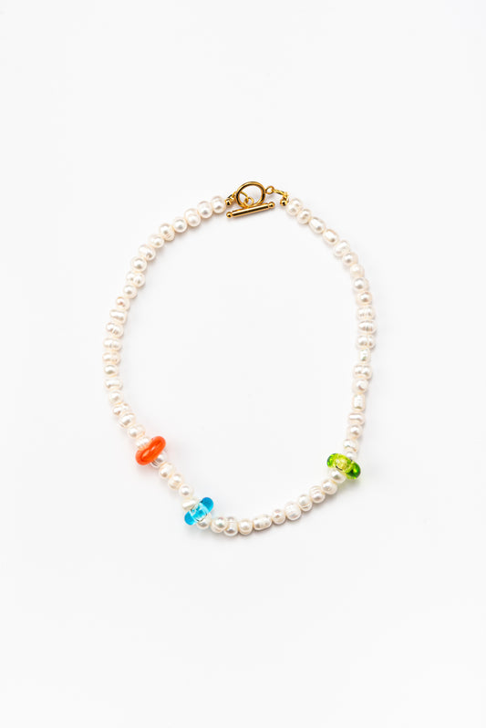 River pearl necklace with orange, blue, and green accents in the form of donuts, made from recycled glass, and a gold toggle clasp