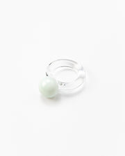 A clear Bolon ring with a white sphere on top, handcrafted from recycled glass