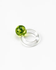 A clear Bolon ring with an apple green sphere on top, handcrafted from recycled glass