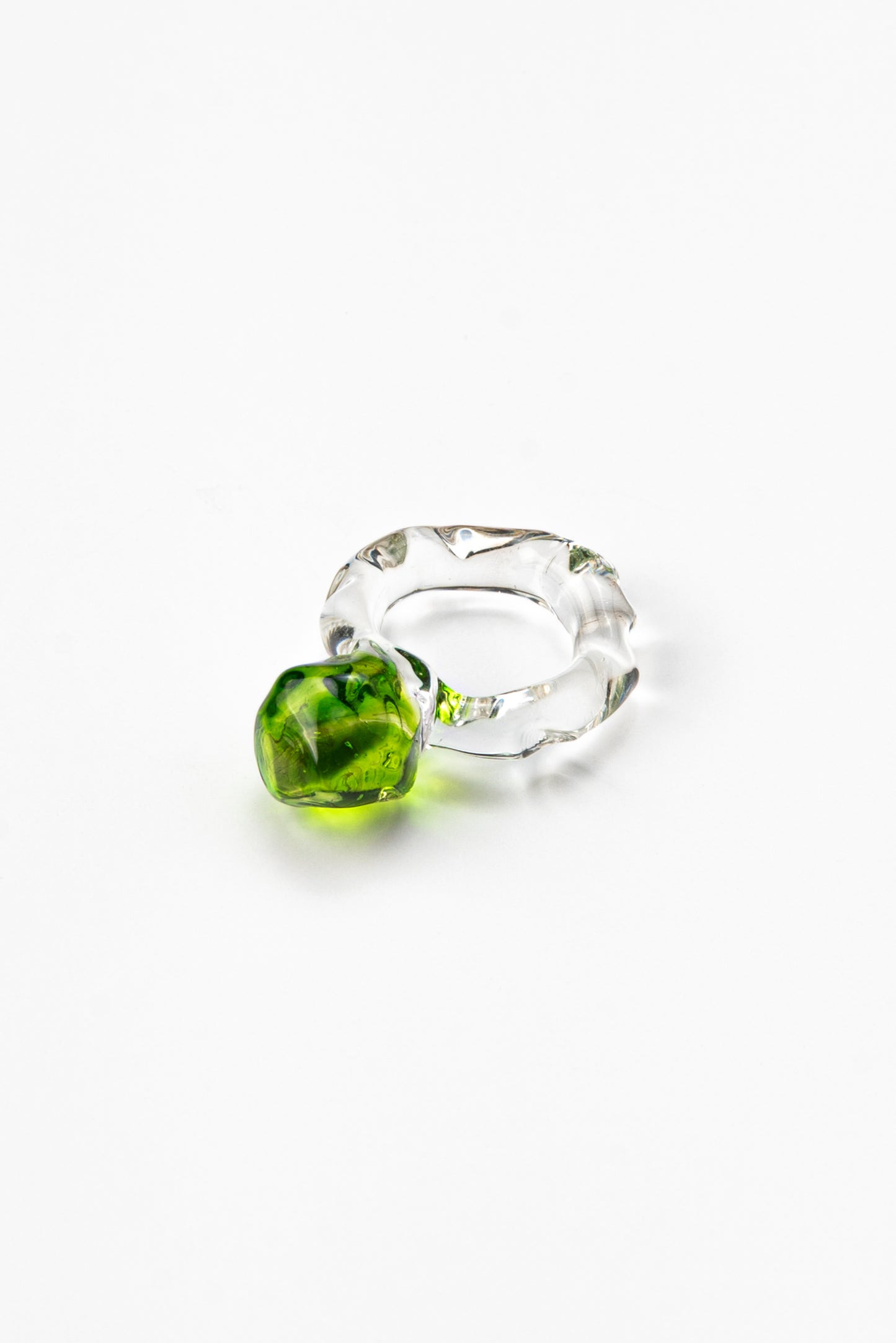 A clear Bolon ring with an apple green sphere on top, handcrafted from recycled glass