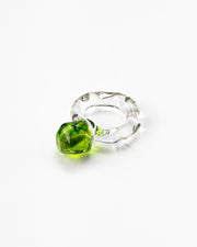A clear Bolon ring with an apple green sphere on top, handcrafted from recycled glass