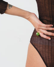 A clear Bolon ring with an apple green sphere on top, handcrafted from recycled glass