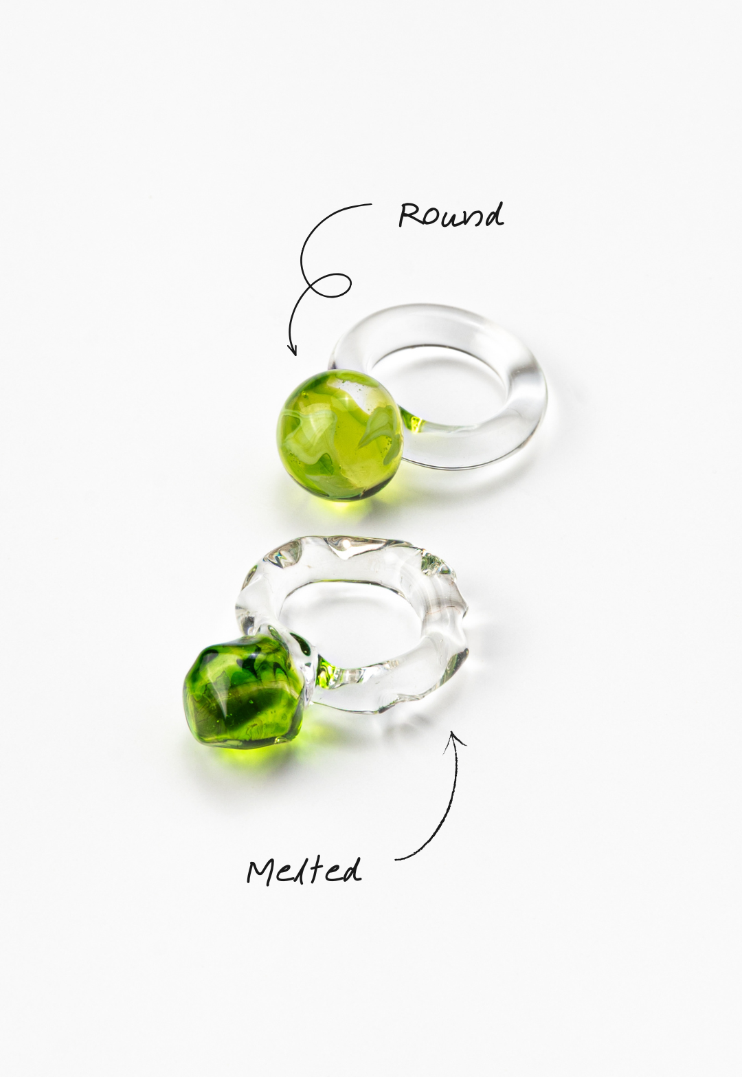 Two different styles of clear Bolon ring with an apple green sphere on top, handcrafted from recycled glass