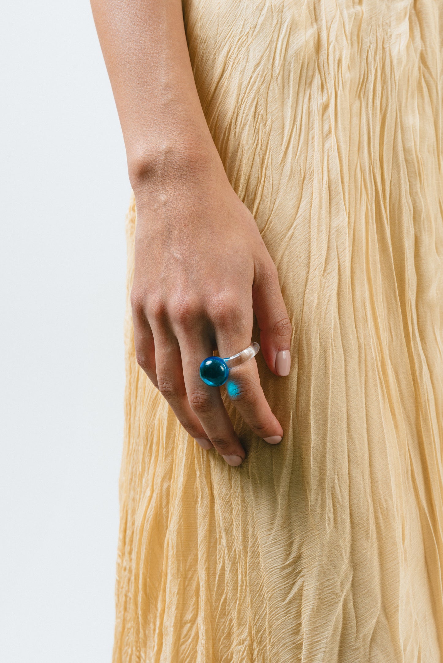 A clear Bolon ring with a sky blue-coloured sphere on top, handcrafted from recycled glass