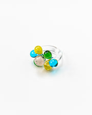 Clear ring with glass spheres, bubbles in green, yellow, turquoise, and peach tones, made from recycled glass.