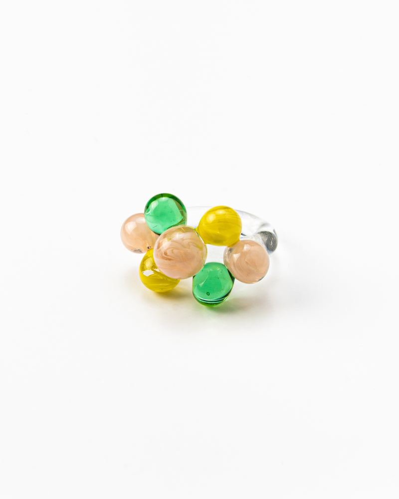 Clear ring with glass spheres, bubbles in green, yellow, and peach tones, made from recycled glass.