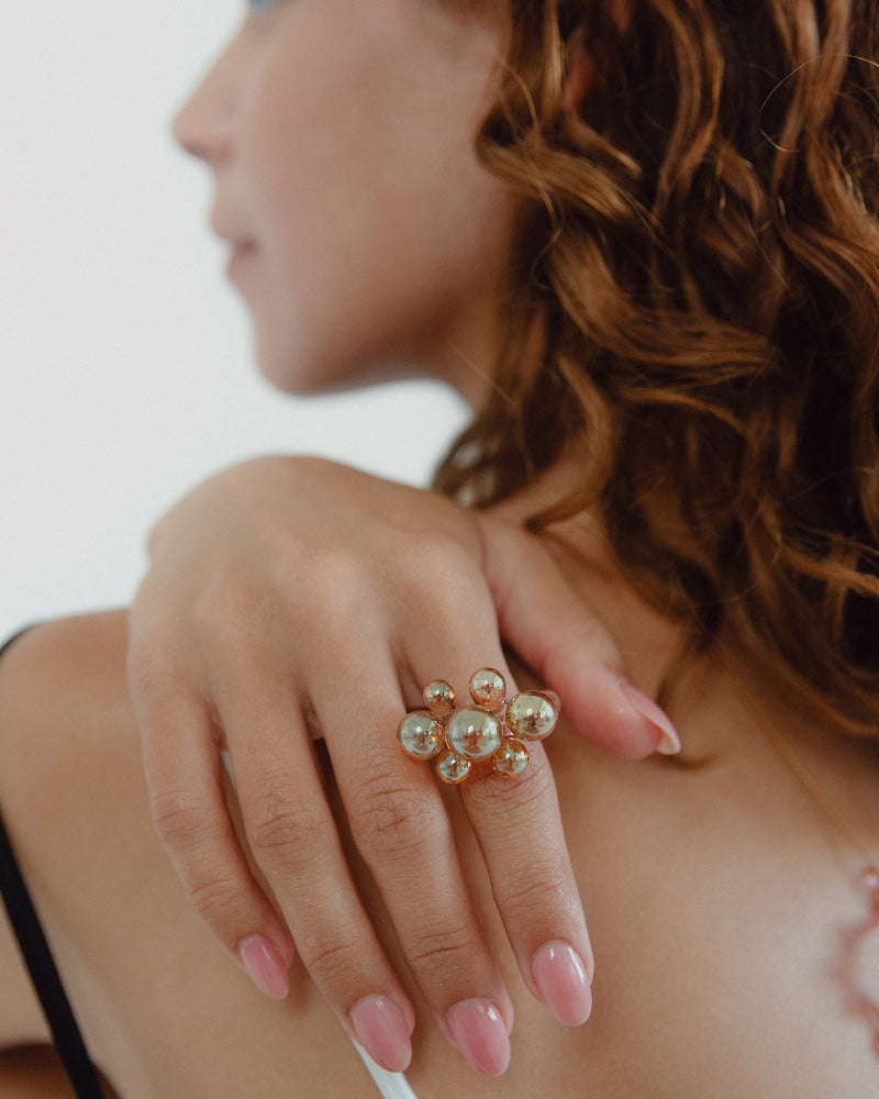A ring with a cluster of iridescent spheres, made from recycled glass.