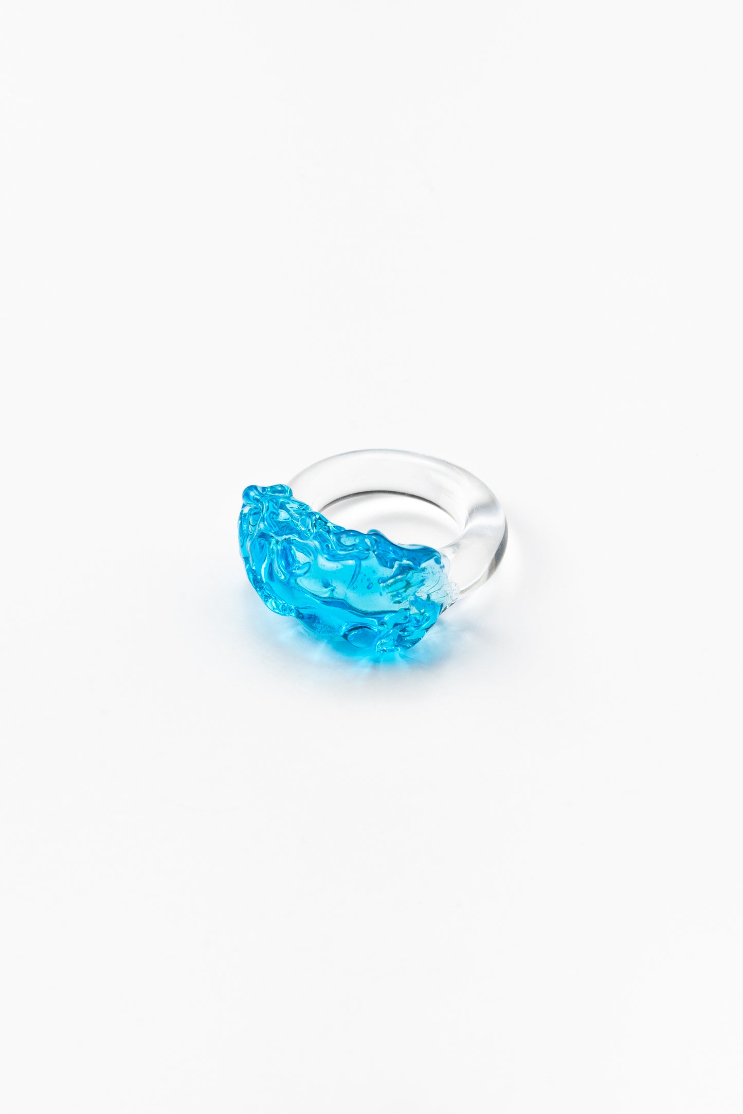 Clear ring with a turquoise textured glass detail on top, made from recycled glass.